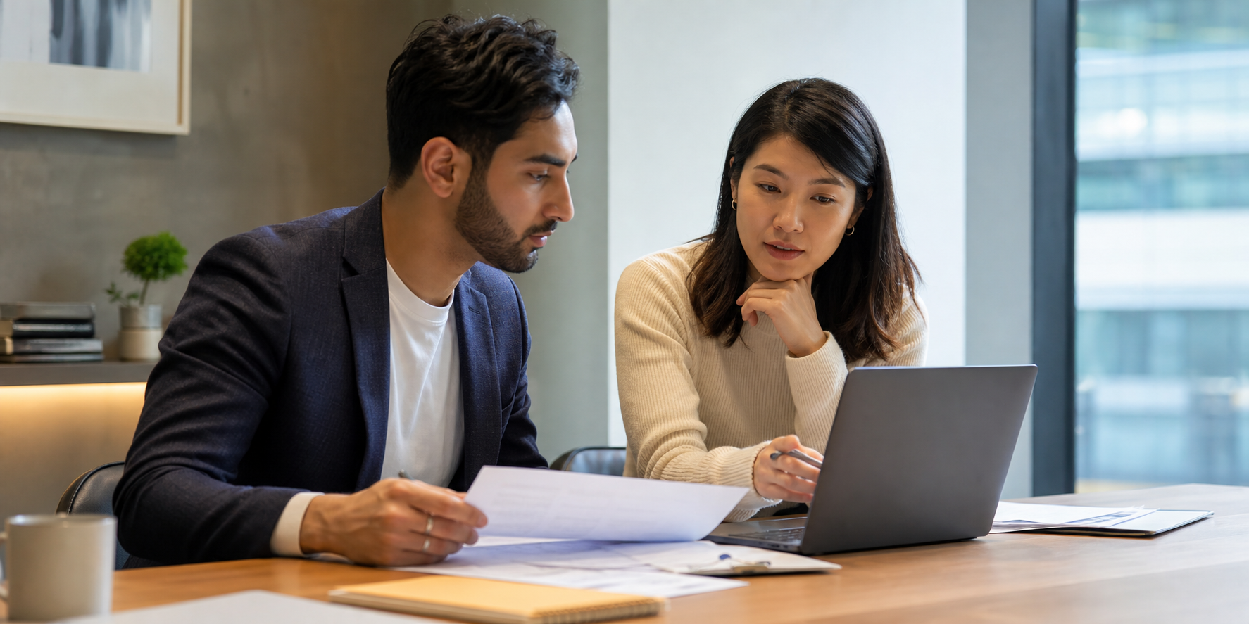 Two Executives Reviewing Contracts And Onboarding Notes At Modern Desk